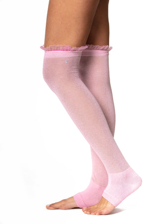 Side view of pink cotton over the knee legwarmer with a fitted heel and ruffle trim on the top seam.