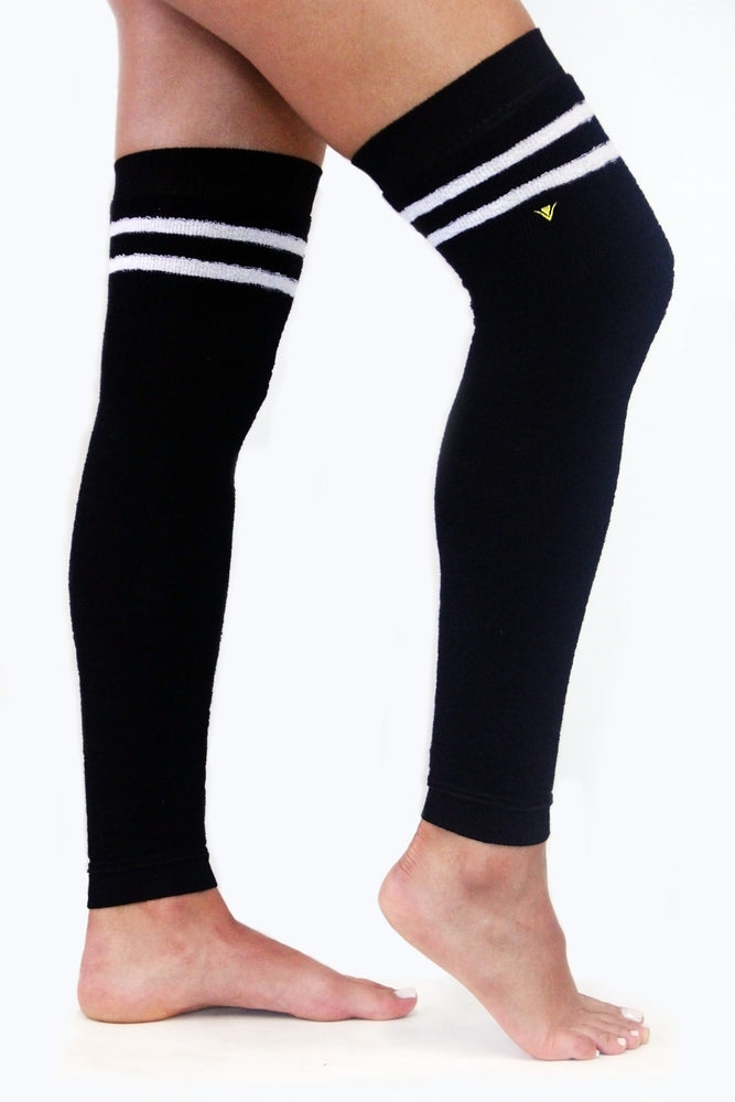 Side view of black terry legwarmers with white stripes accented with a gold Arebesk embroidered logo.