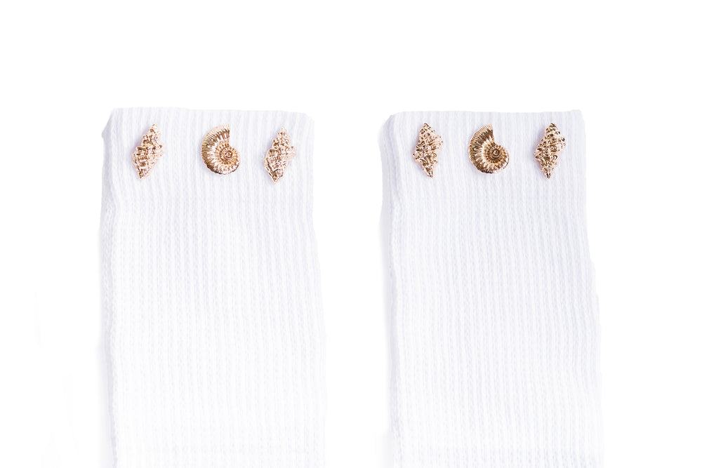 Close up detail of gold seashell jewels adorned to the white cuff of the grip sock.