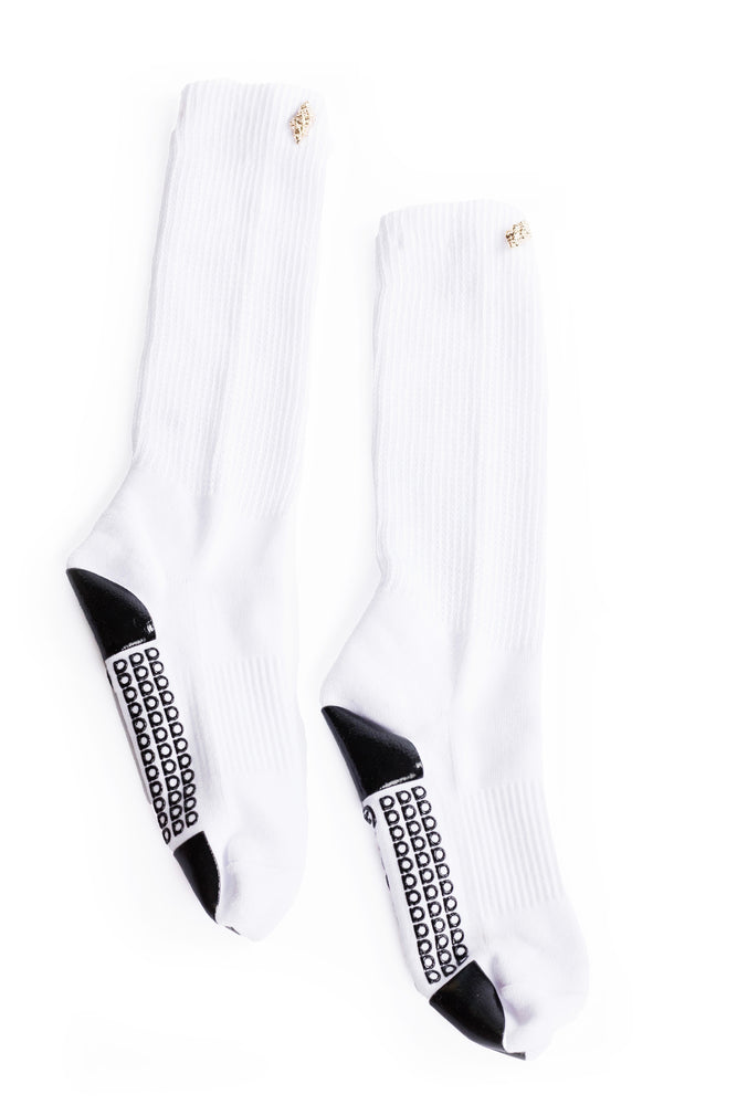White grip socks with gold seashell decoration on the cuff laying on a white background.