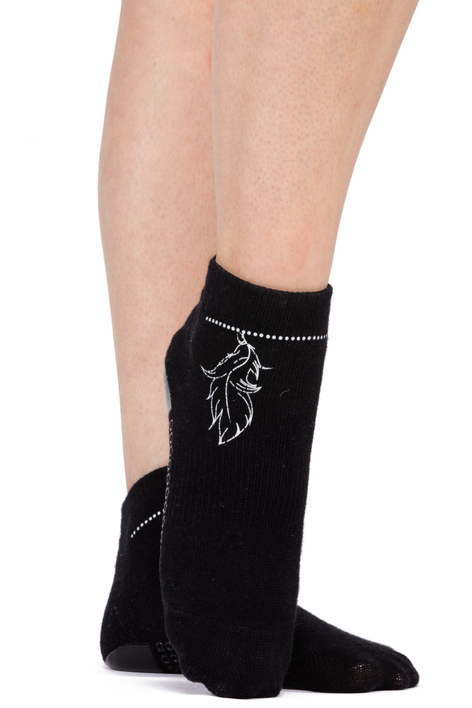 Black ankle grip socks accented with silver metallic foil in the shape of a beaded anklet with a feather hanging from the chain. The chain extends from ankle to ankle on the front side of the foot.