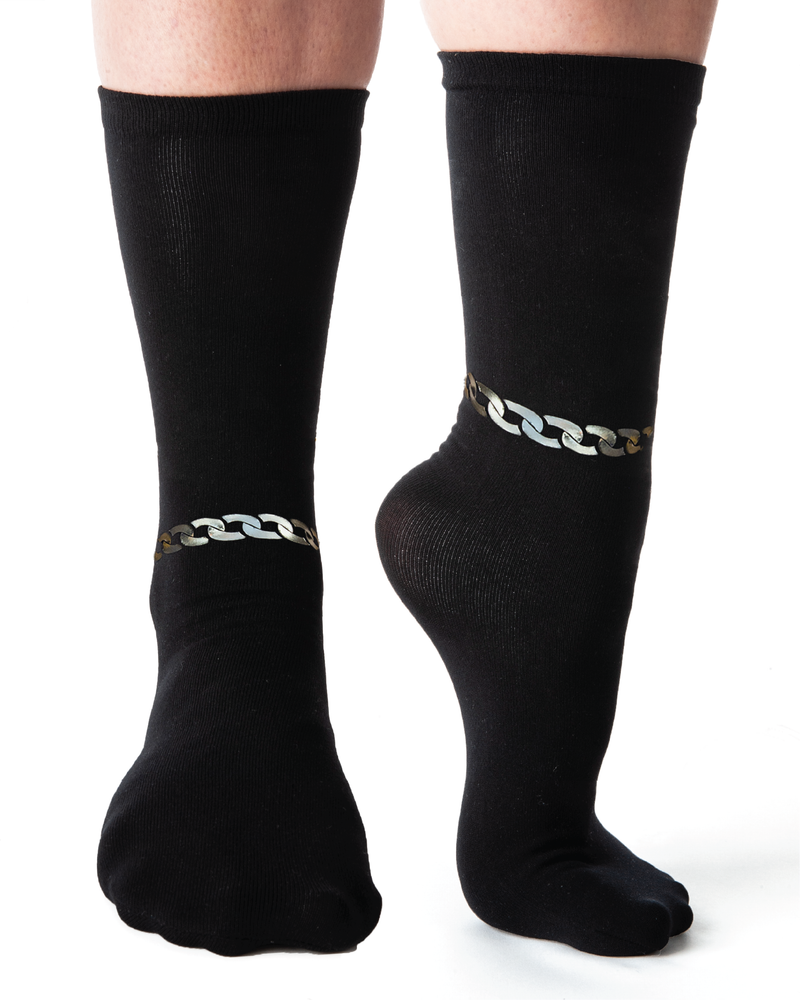 Front view of black sock with metallic chain detailing across ankle.