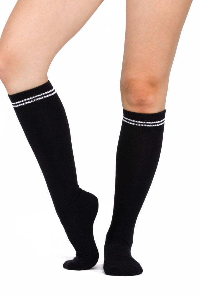 Black knee high grip socks with two white stripes accenting the top of the sock.
