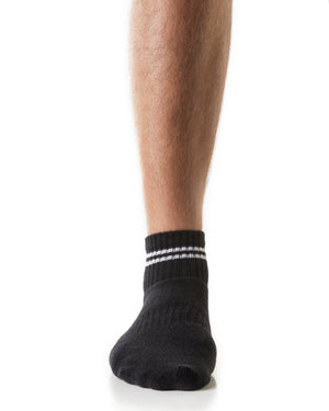 Front view of men's black low crew socks with white stripes and white triangular Arebesk logo.